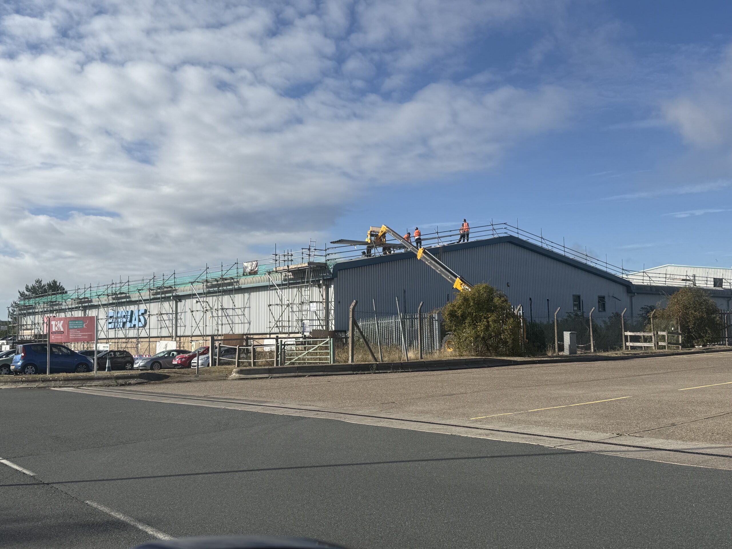 IMG_6192 RDP Cladding team carrying out roof replacement works at Emplas Windows’ Wellingborough factory, with scaffolding and access equipment in place during installation of the new high-performance metal roofing system.