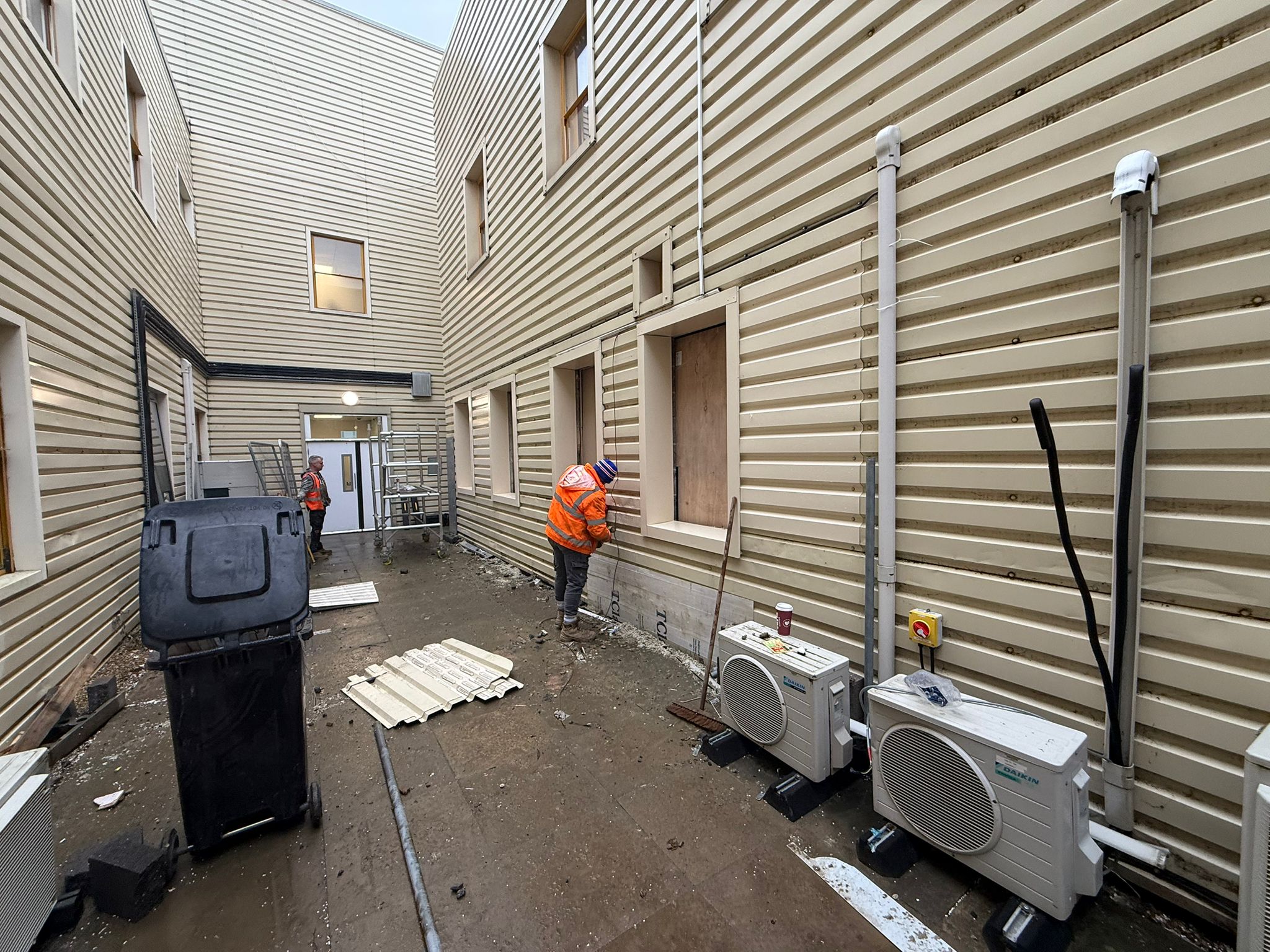 RDP Cladding operatives forming new window openings in existing wall cladding at Milton Keynes University Hospital